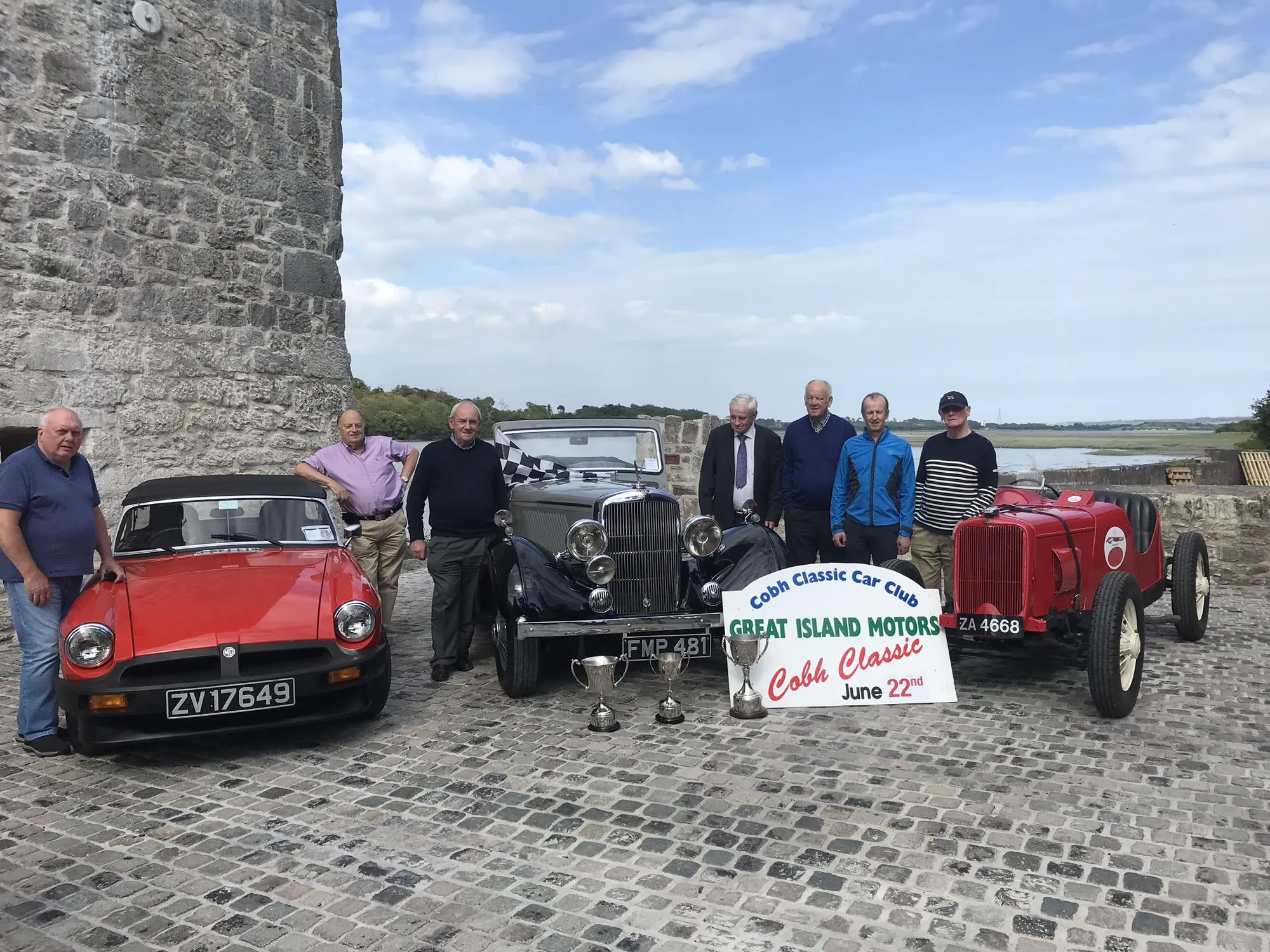 Members of a classic car club with vintage cars on the causeway beside the castle