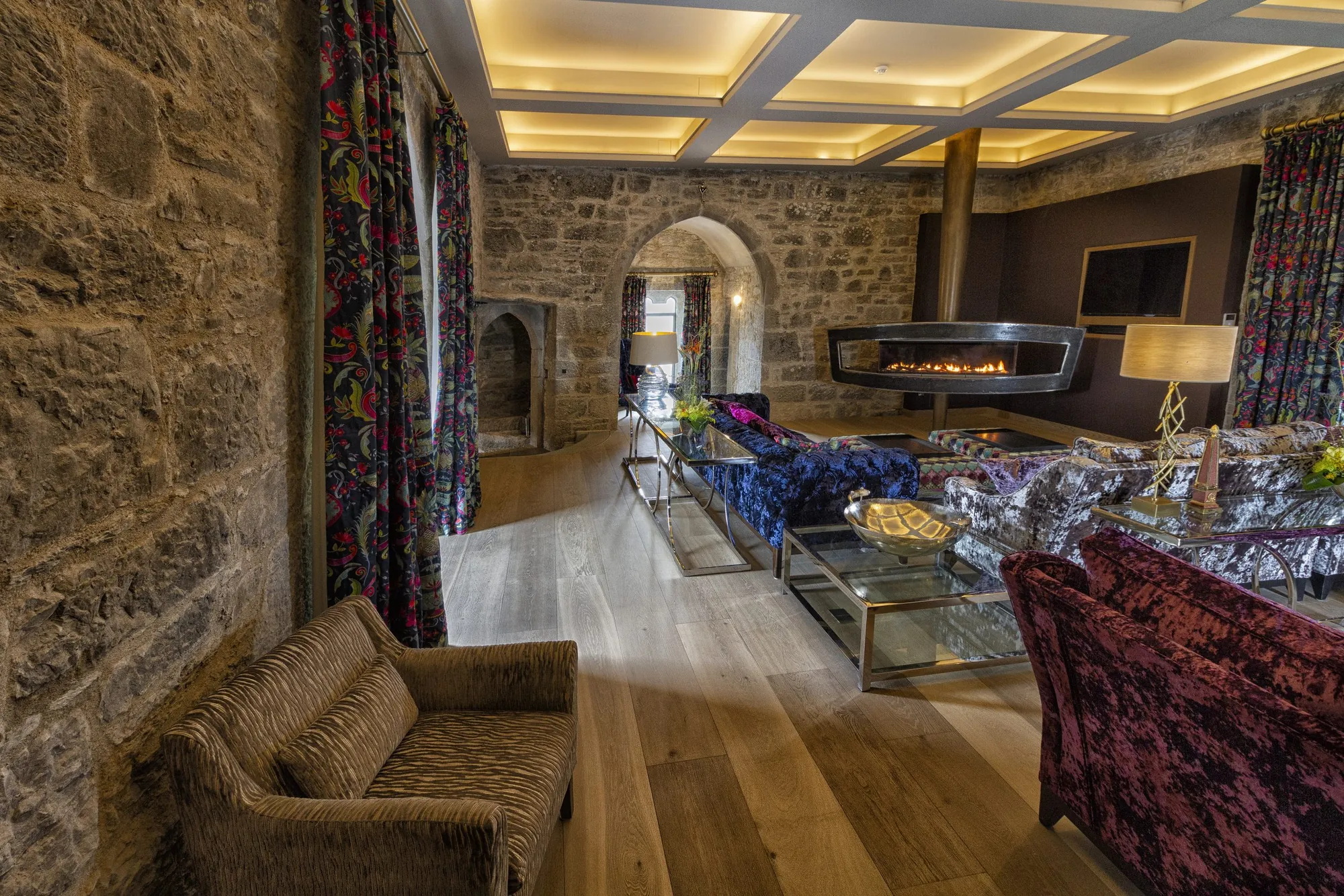 Wider view of the drawing room showing exposed stone and coffered ceiling