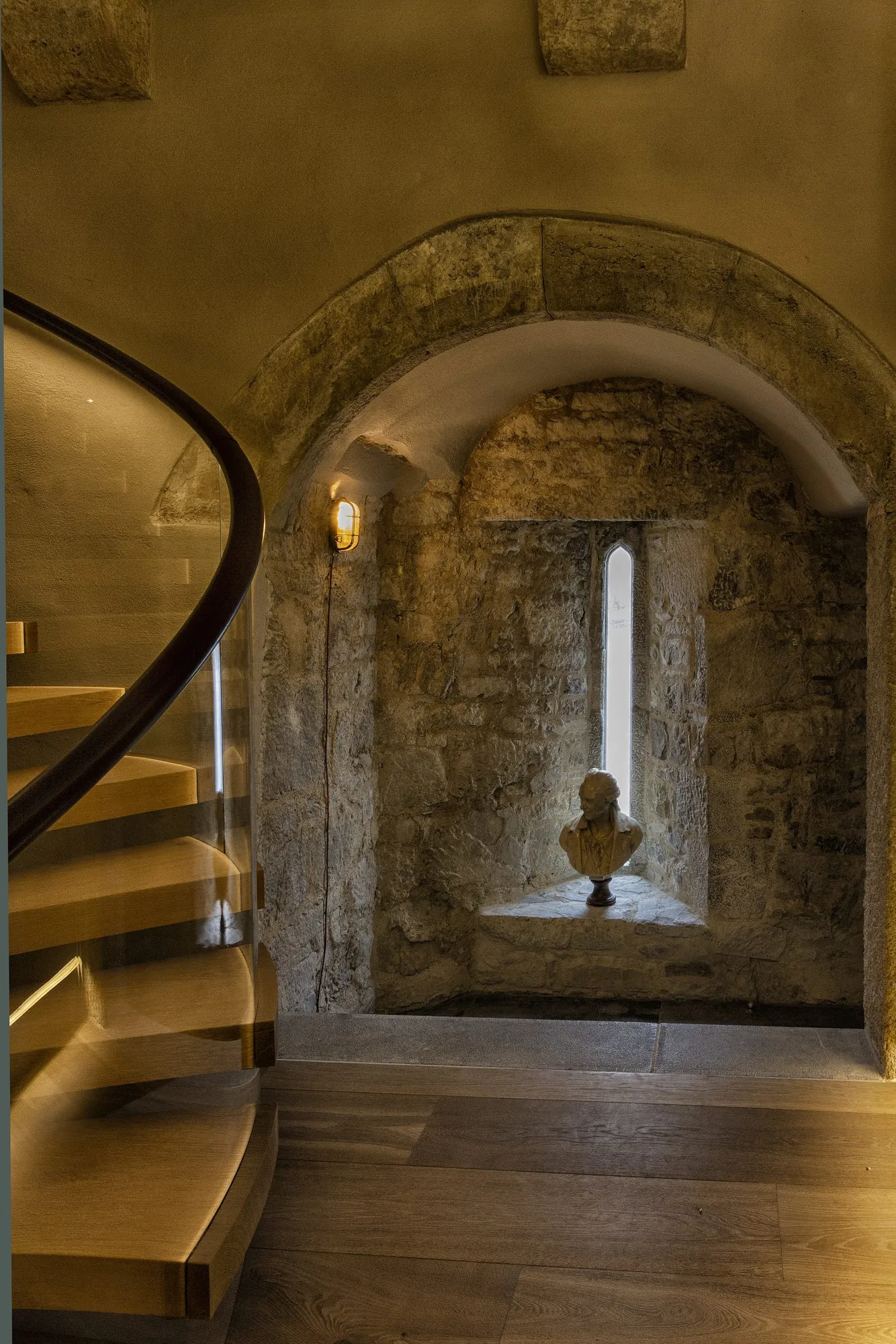 Stone staircase beside a deep arched window embrasure